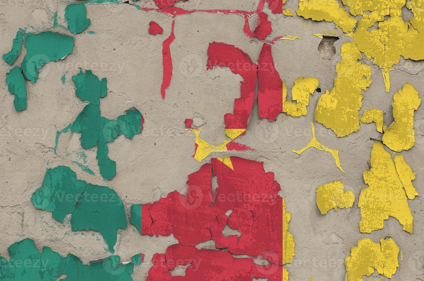 Cameroon flag depicted in paint colors on old obsolete messy concrete wall closeup. Textured banner on rough background photo