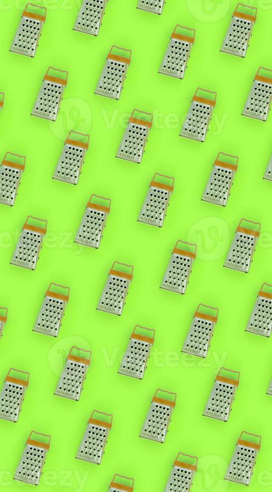 Small stainless steel graters lies on a pastel colored paper. Kitchen accessories. Tools for cooking. Flat lay top view photo