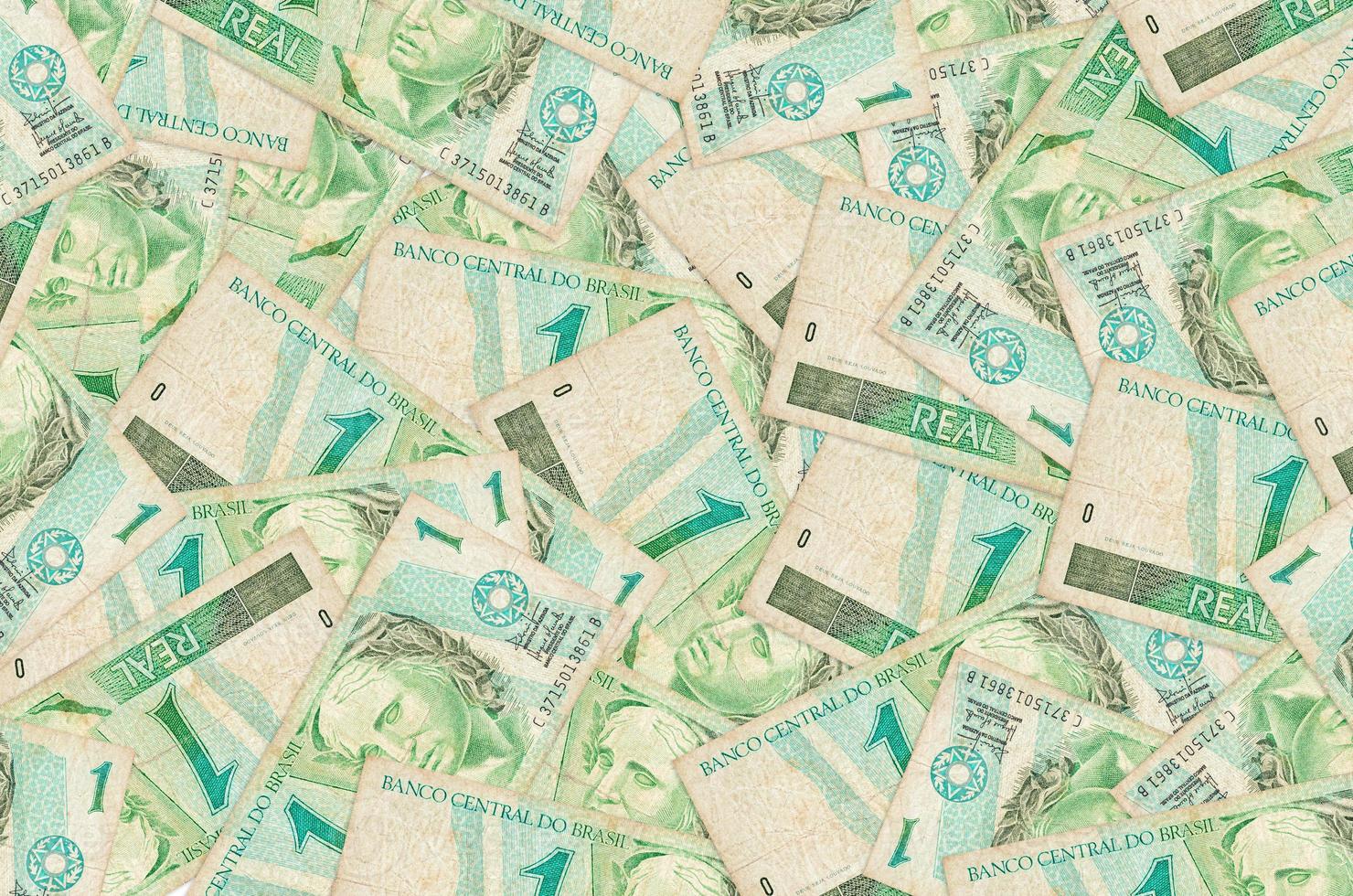 1 Brazilian real bills lies in big pile. Rich life conceptual background photo