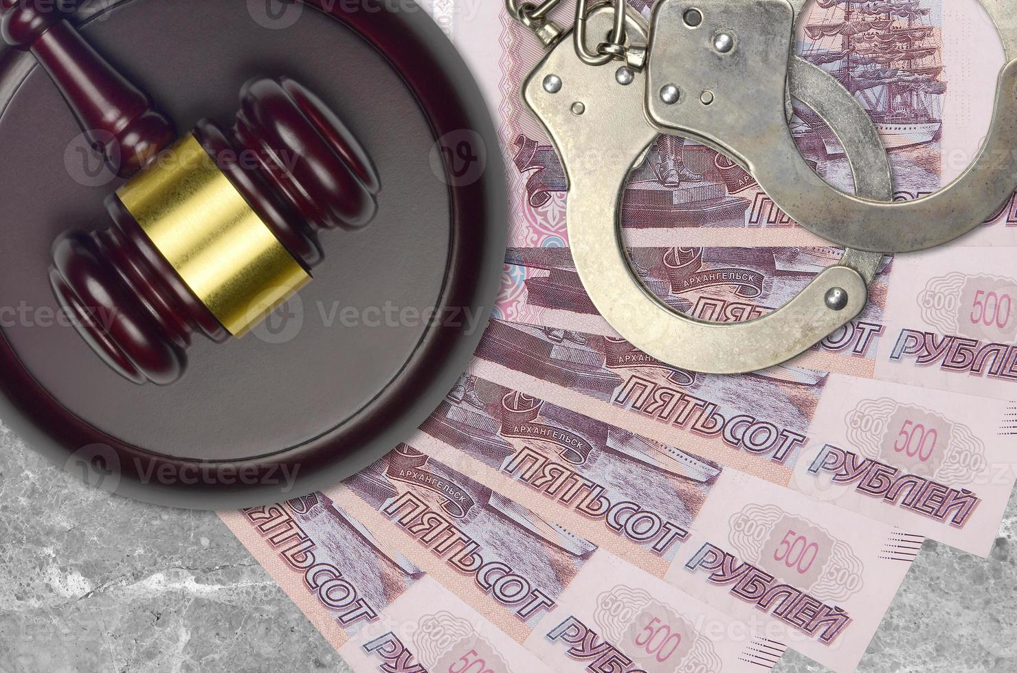 500 russian rubles bills and judge hammer with police handcuffs on court desk. Concept of judicial trial or bribery. Tax avoidance photo