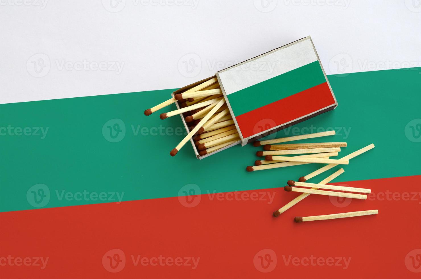 Bulgaria flag  is shown on an open matchbox, from which several matches fall and lies on a large flag photo