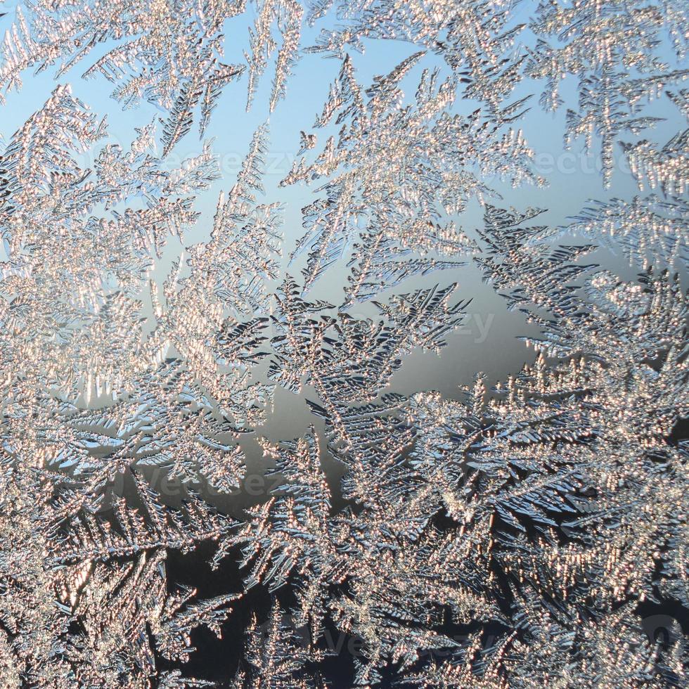 Snowflakes frost rime macro on window glass pane photo