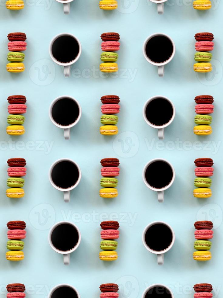 A pattern of many colorful dessert cake macaroon and coffee cups on trendy pastel blue background top view. Flat lay composition photo