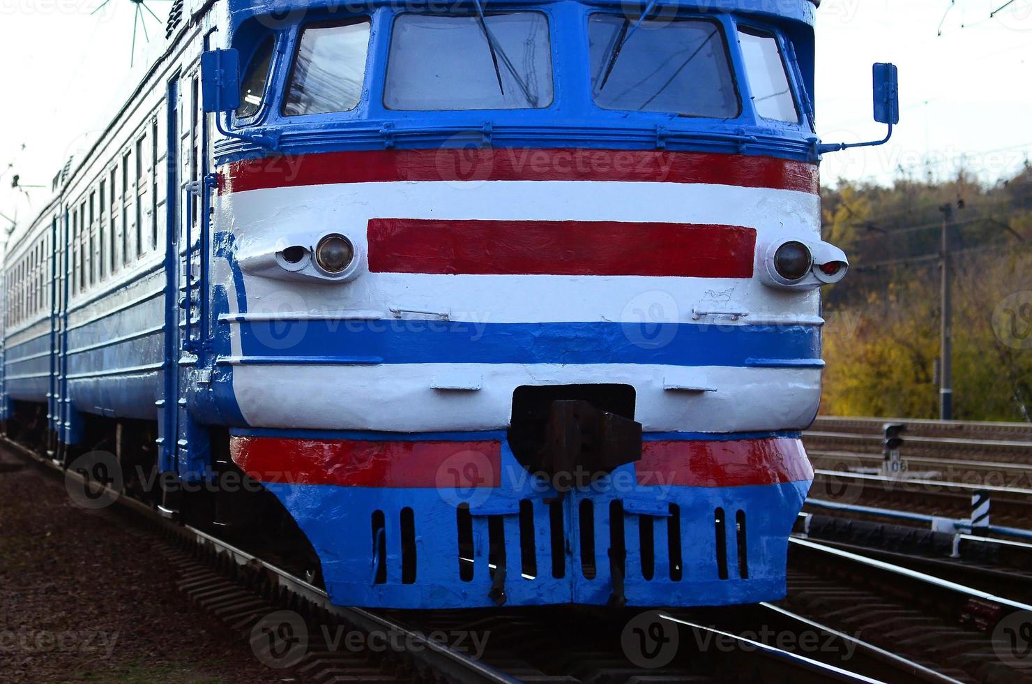 Old soviet electric train with outdated design moving by rail photo