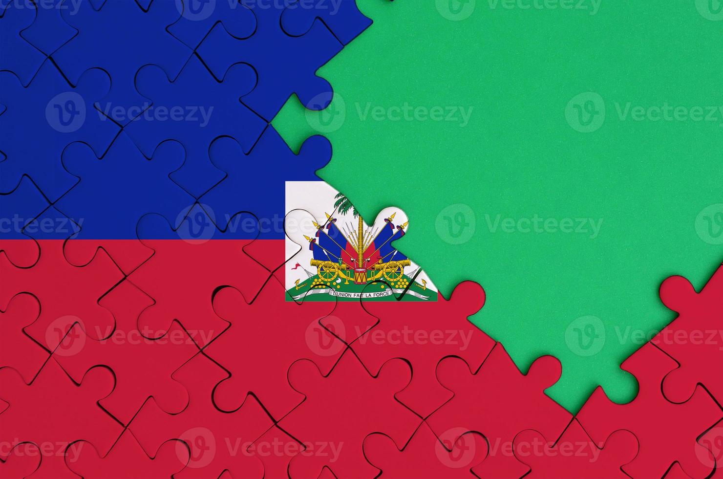 Haiti flag  is depicted on a completed jigsaw puzzle with free green copy space on the right side photo