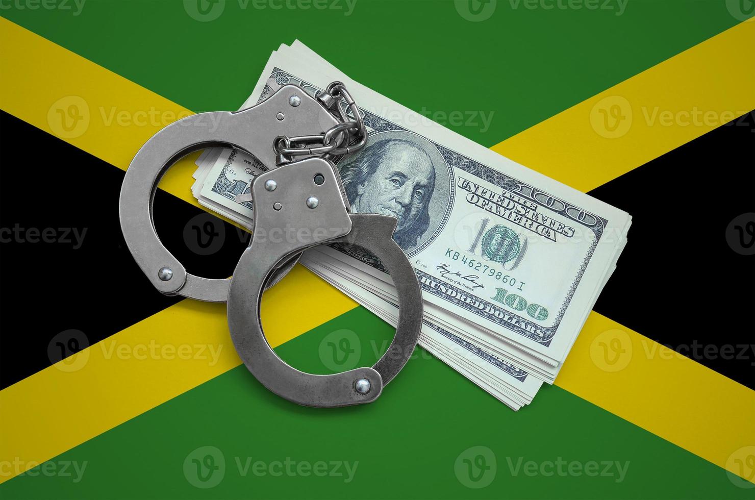 Jamaica flag  with handcuffs and a bundle of dollars. Currency corruption in the country. Financial crimes photo