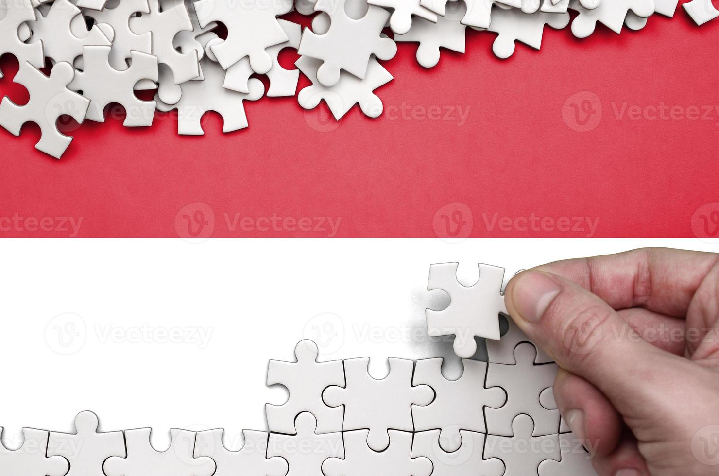 Indonesia flag  is depicted on a table on which the human hand folds a puzzle of white color photo