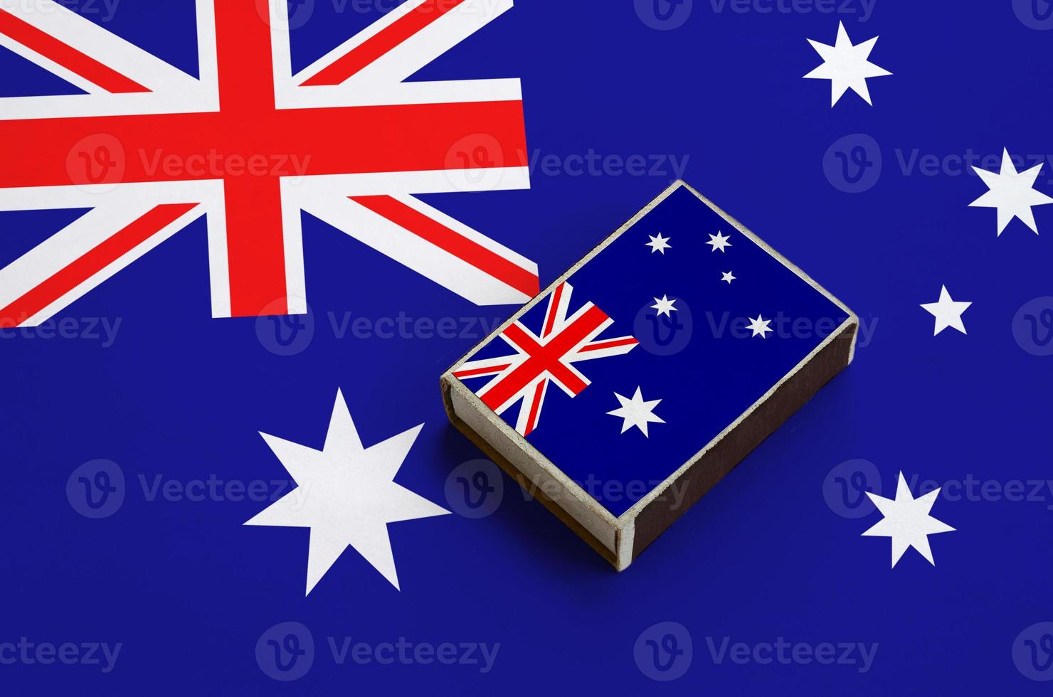Australia flag  is pictured on a matchbox that lies on a large flag photo