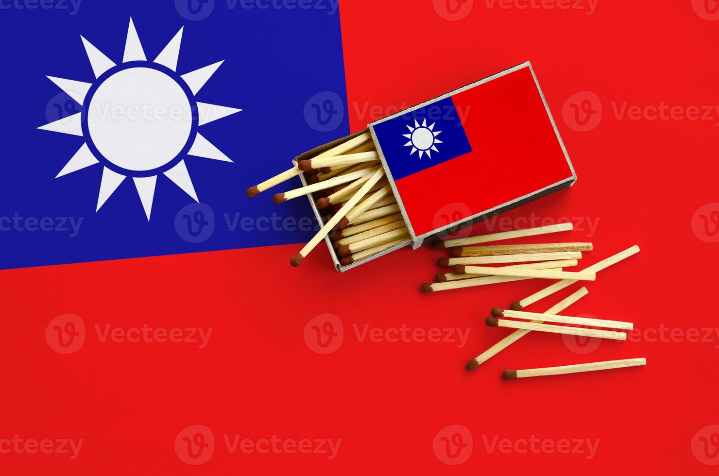 Taiwan flag  is shown on an open matchbox, from which several matches fall and lies on a large flag photo