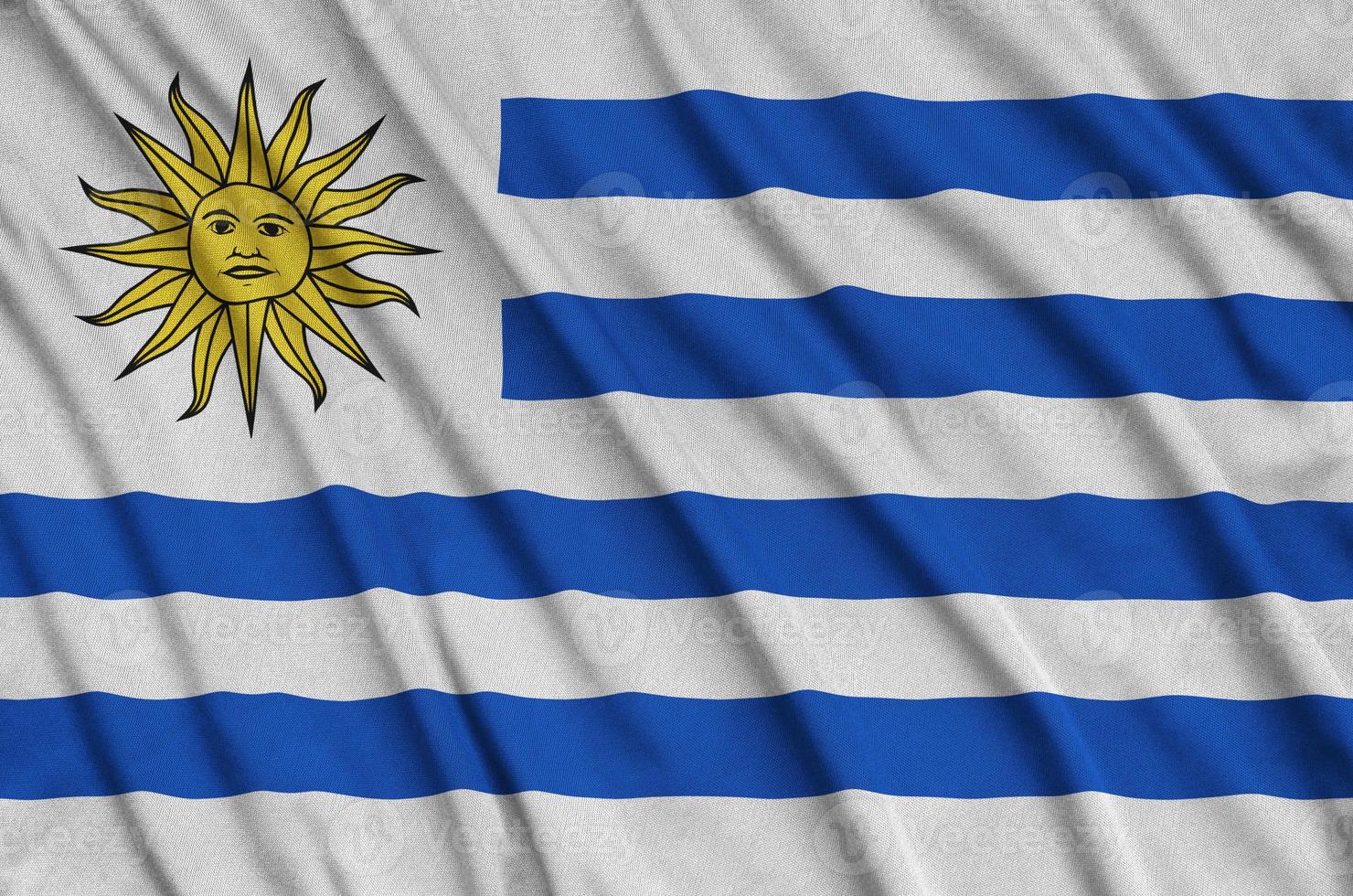 Uruguay flag  is depicted on a sports cloth fabric with many folds. Sport team banner photo