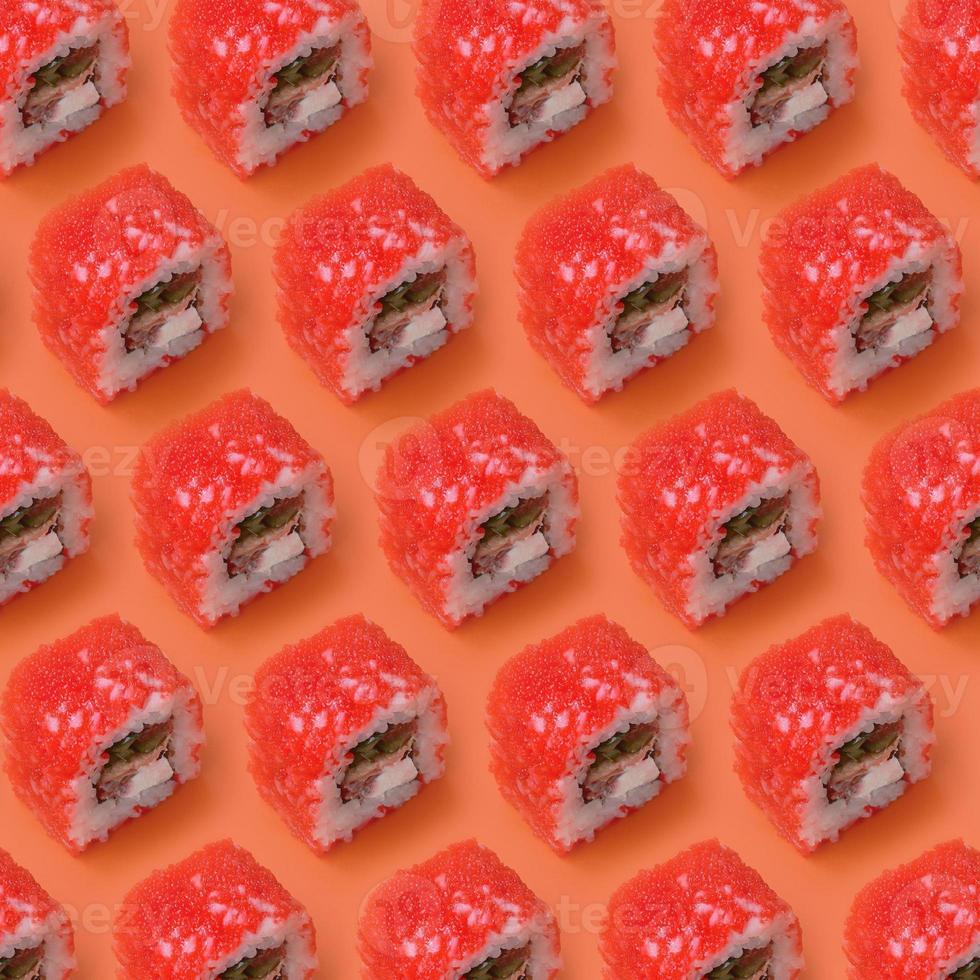 California Maki sushi rolls with caviar and masago on orange background. Minimalism top view flat lay pattern with Japanese food photo
