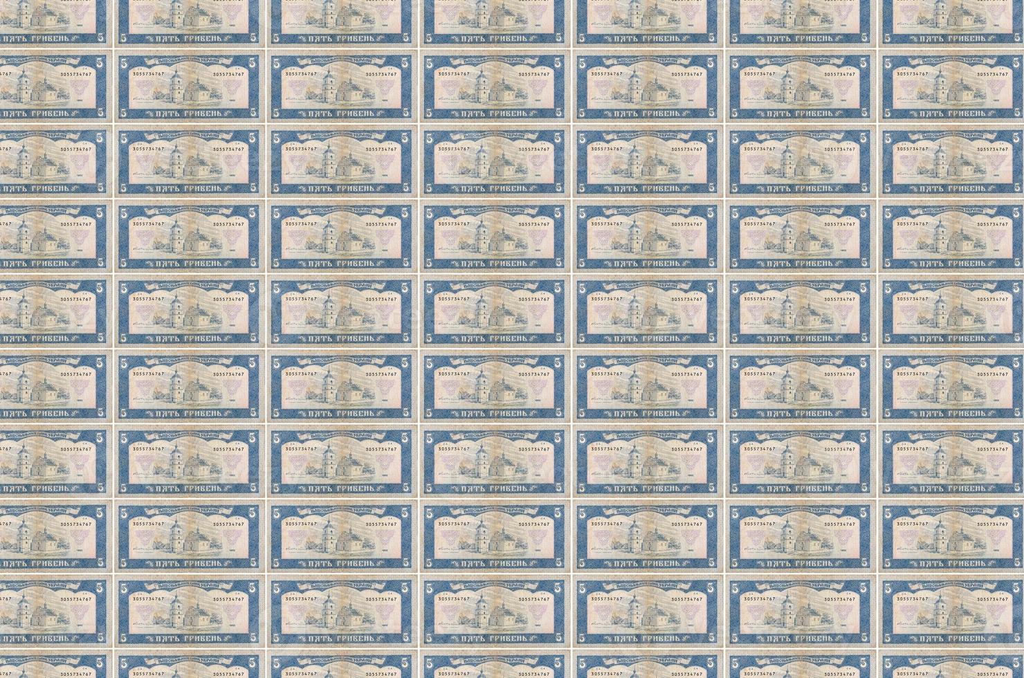 5 Ukrainian hryvnias bills printed in money production conveyor. Collage of many bills. Concept of currency devaluation photo