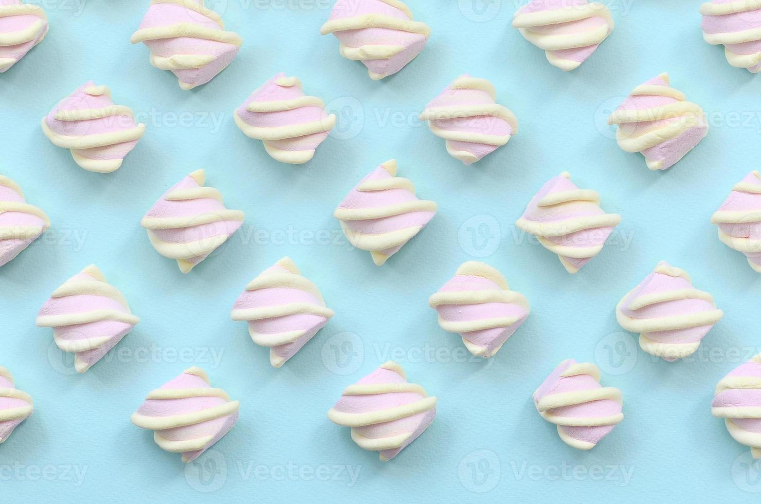 Colorful marshmallow laid out on blue paper background. pastel creative textured pattern. minimal photo