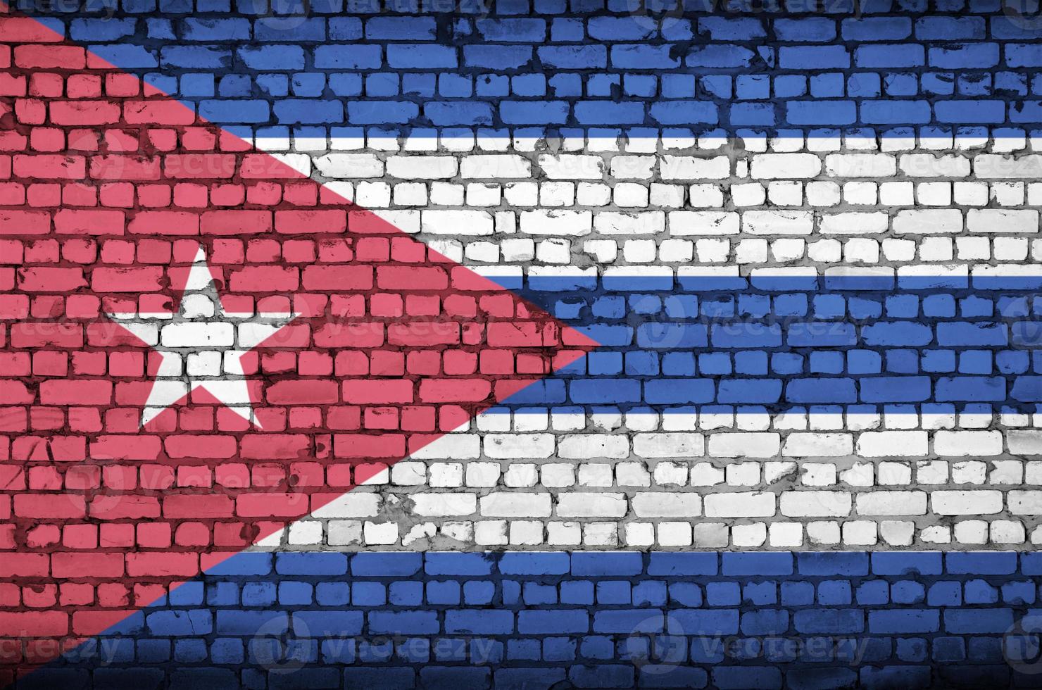 Cuba flag is painted onto an old brick wall photo