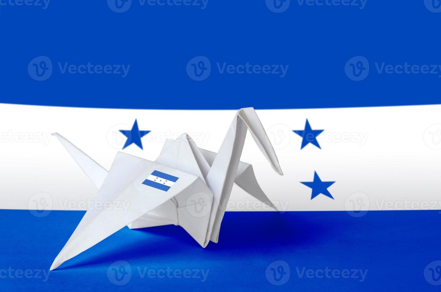 bandera de honduras representada en el ala de la grúa de origami de papel. concepto de artes hechas a mano foto