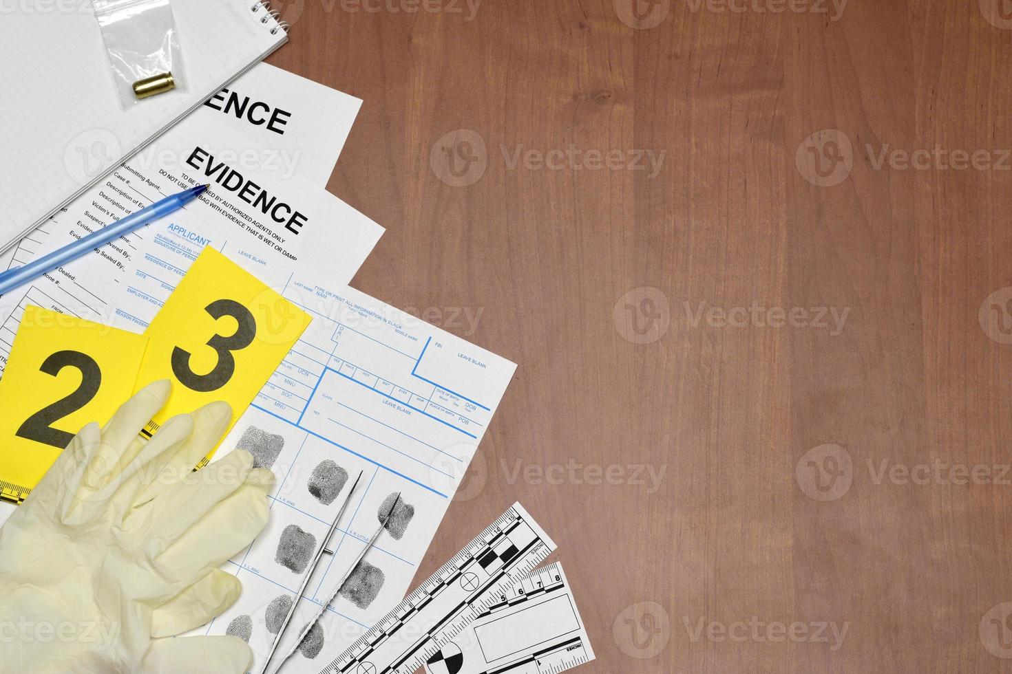 Paperwork during crime scene investigation process in csi laboratory. Evidence labels with fingerprint applicant and rubber gloves on vooden table photo