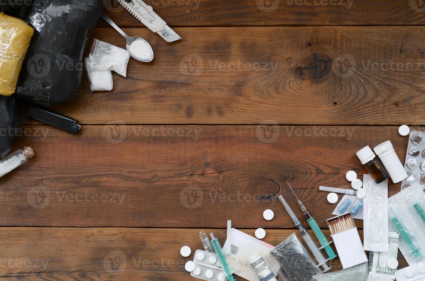 A lot of narcotic substances and devices for the preparation of drugs lie on an old wooden table photo