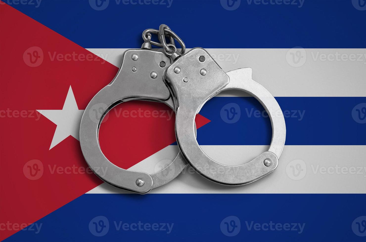 Cuba flag  and police handcuffs. The concept of observance of the law in the country and protection from crime photo