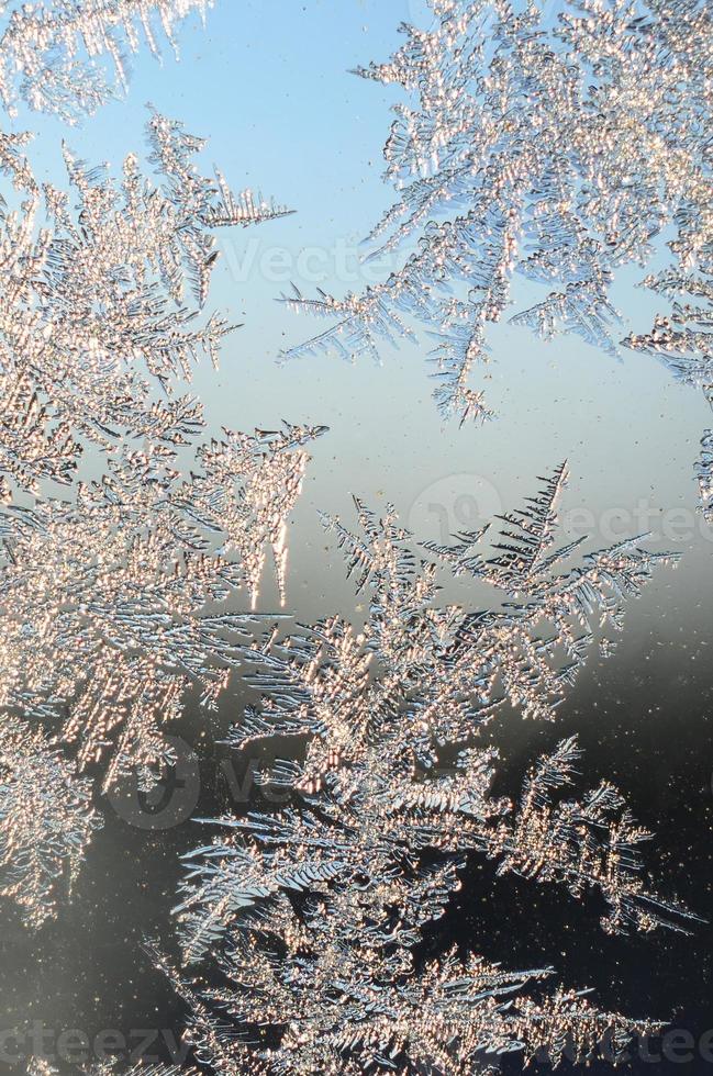 Snowflakes frost rime macro on window glass pane photo