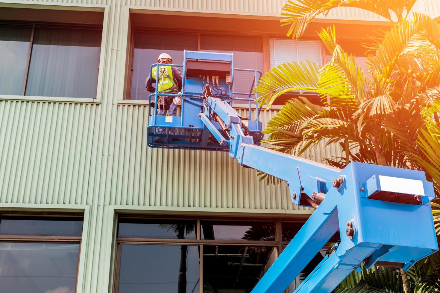 High-rise building maintenance engineers using cranes photo