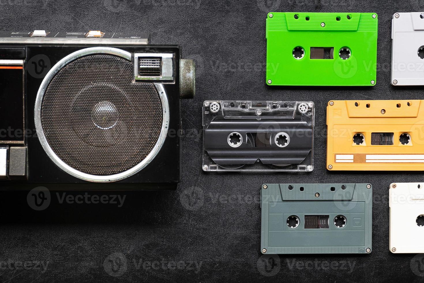 Top view half retro radio and colorful cassette tape on black floor with copy space photo