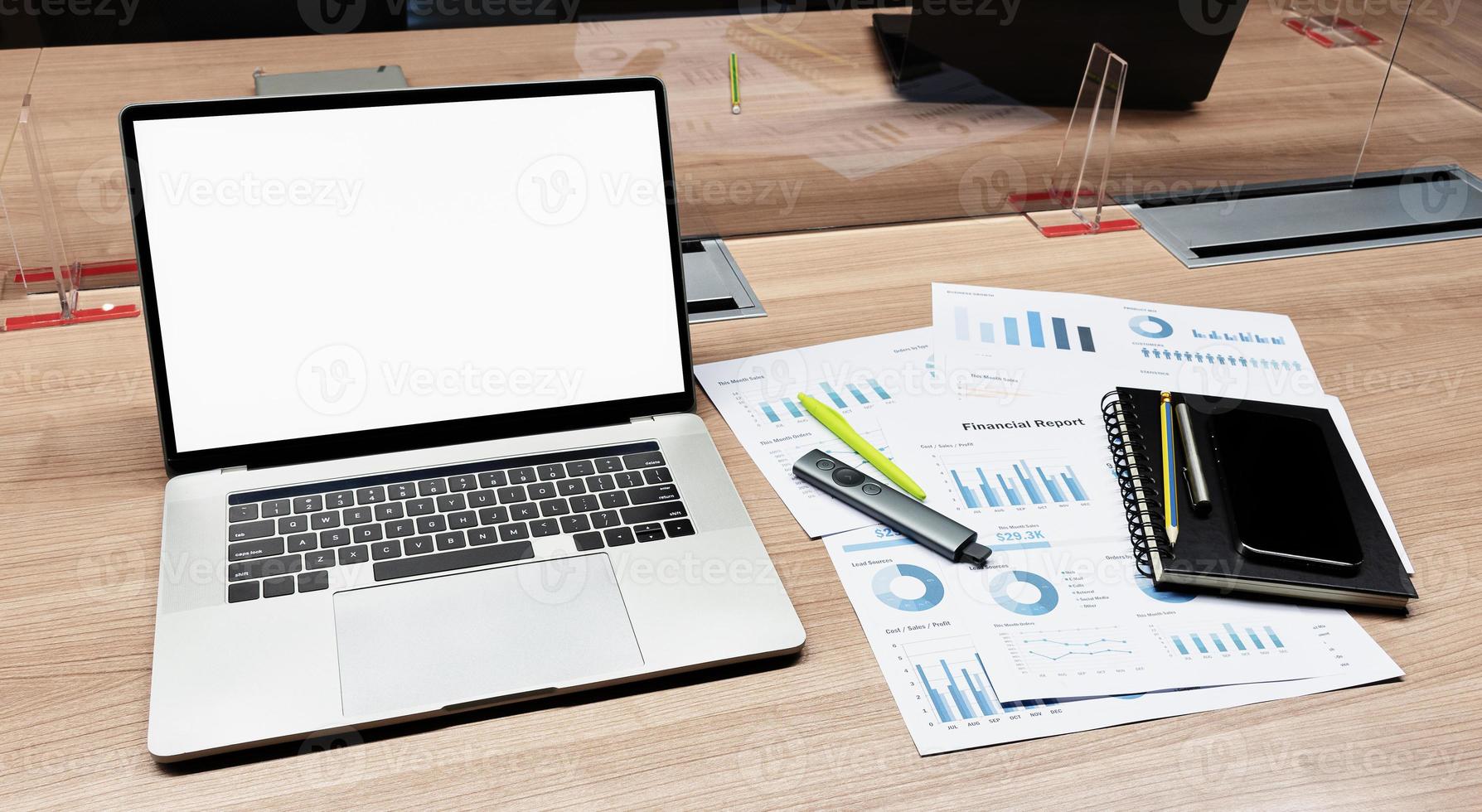 White screen on display laptop and paperwork on table in meeting room photo