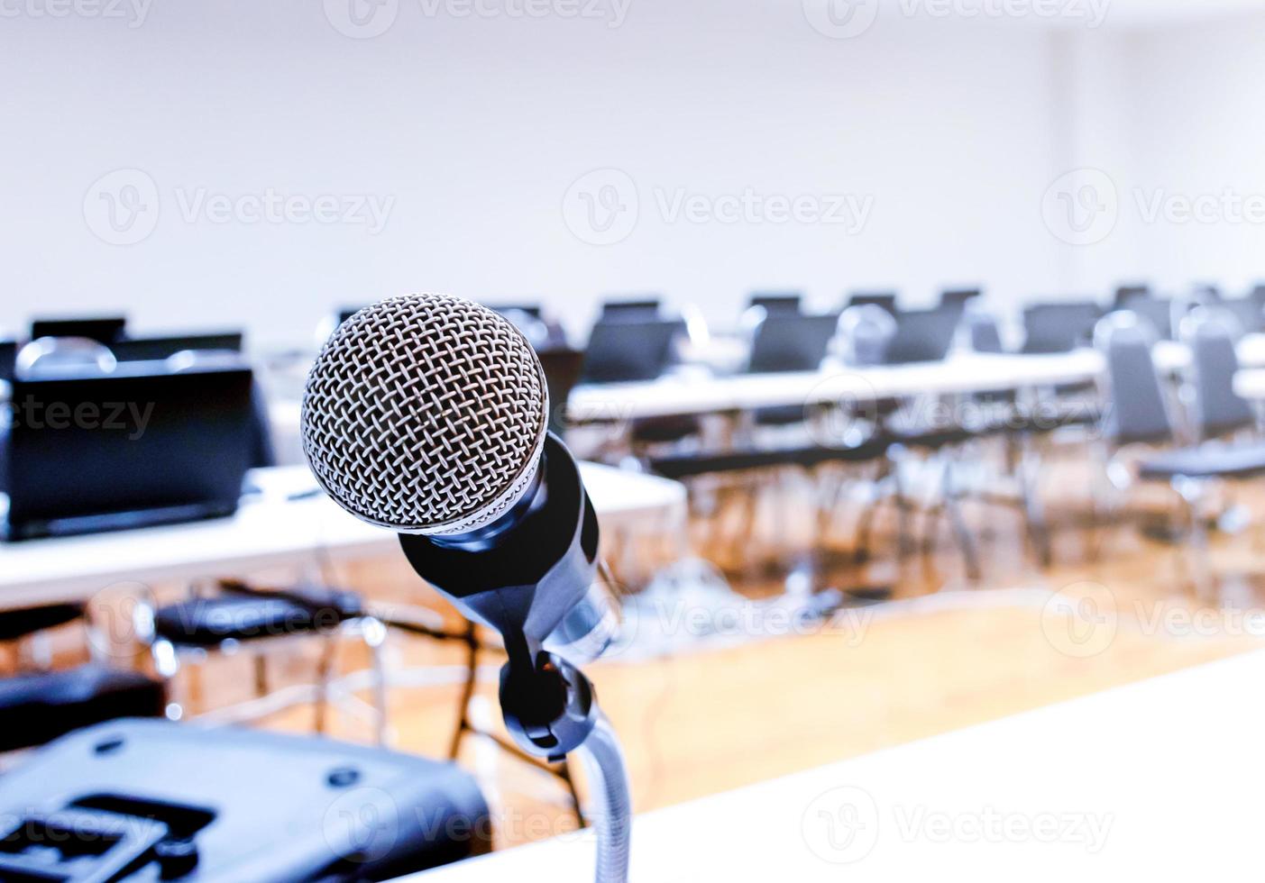 Micrófono y portátil sobre el discurso borroso abstracto en la sala de seminarios foto