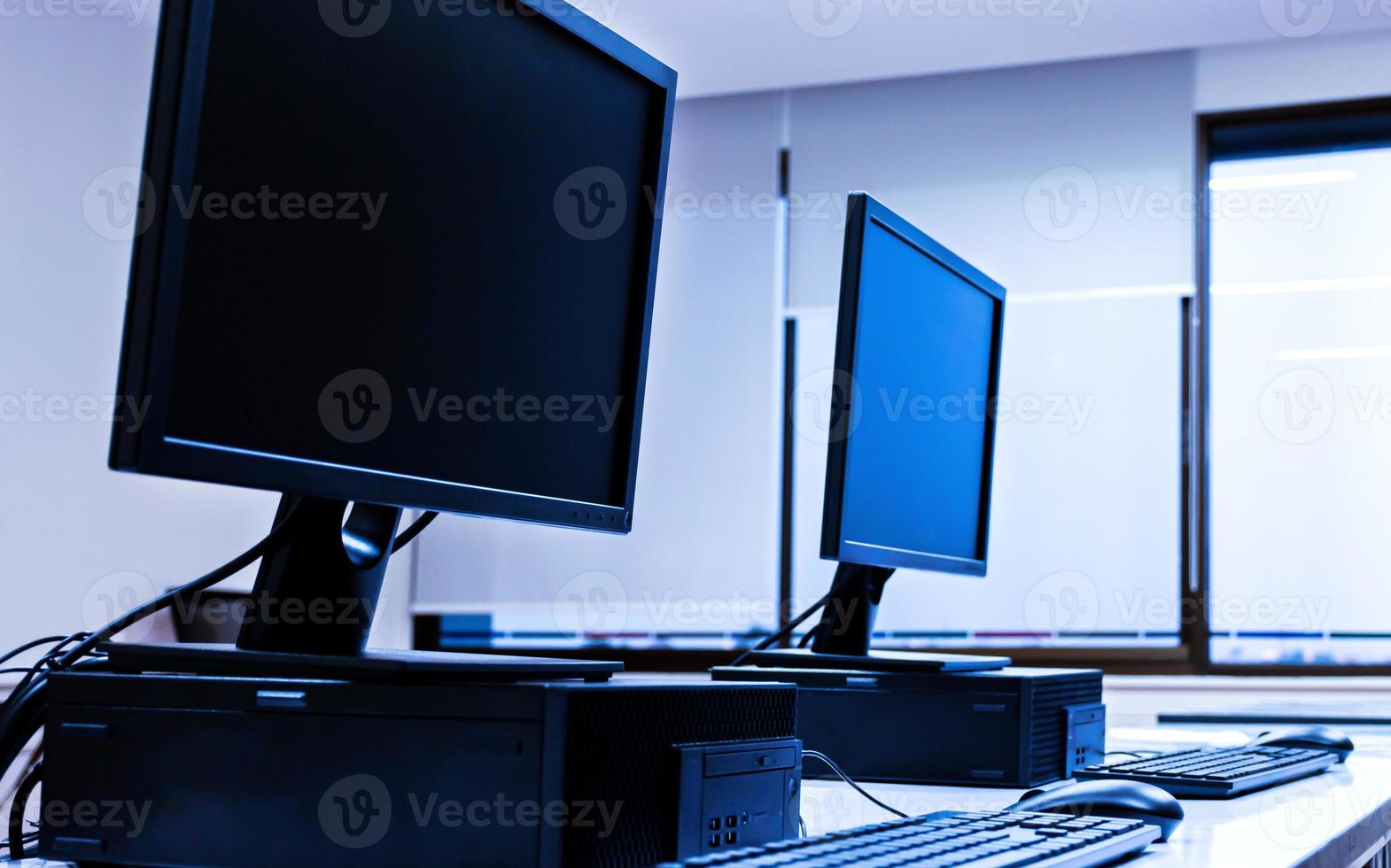 fila de computadoras y monitores en clase de computación foto