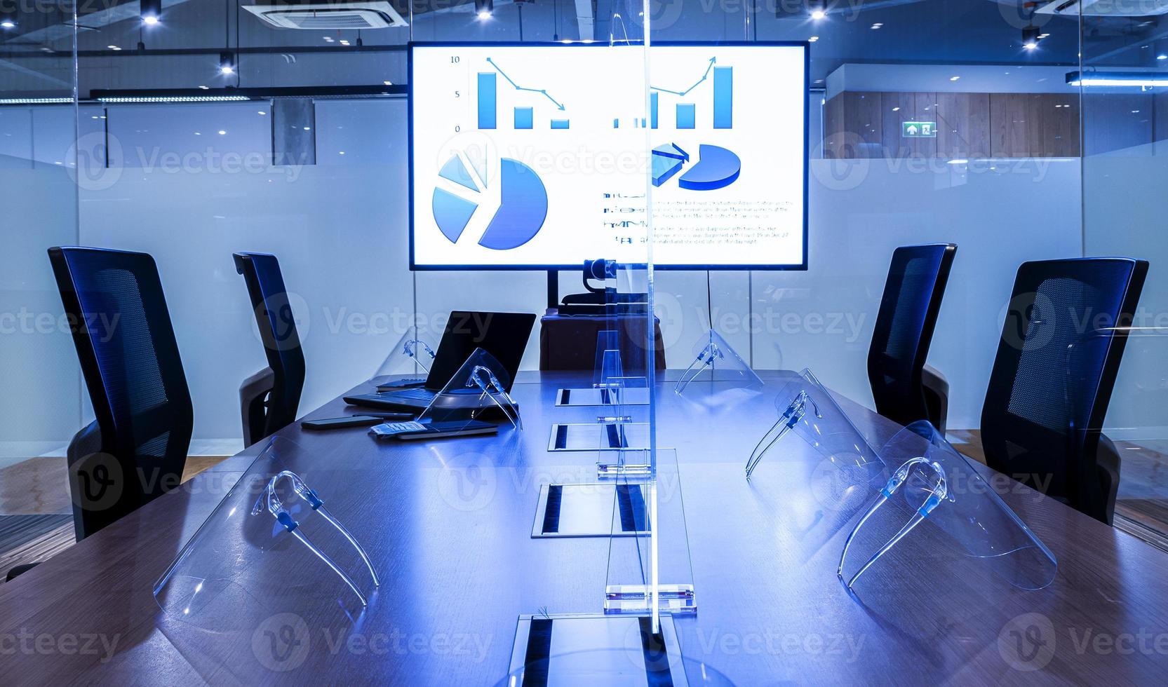Presentation slide show on display television with clear acrylic sheet separatescenter on  table to prevent COVID-19 and face shield photo