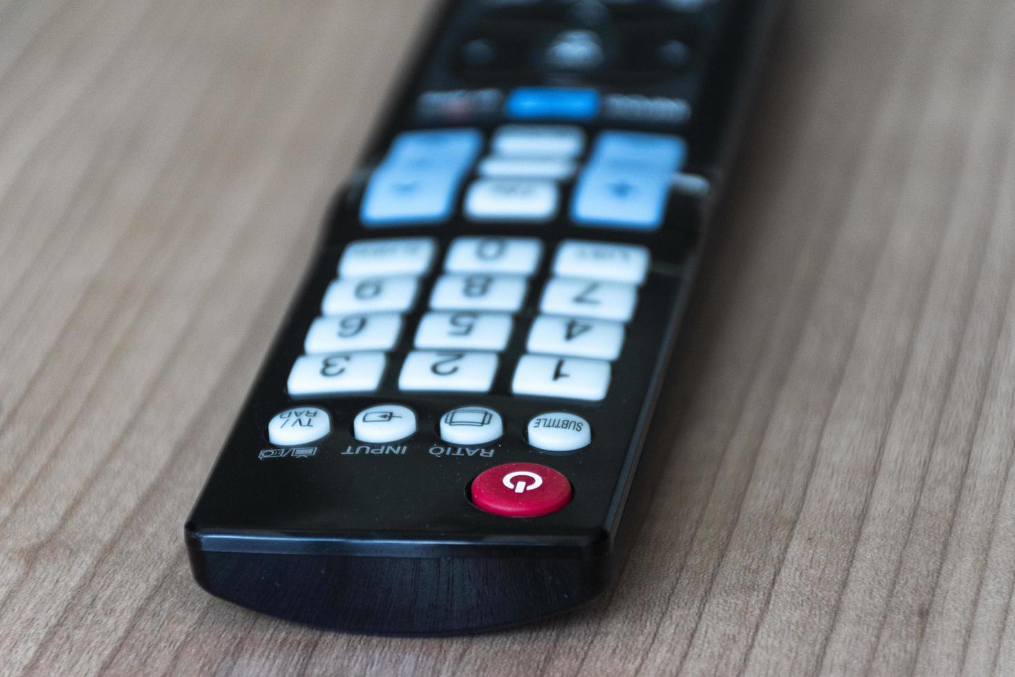 Remote control television on wooden table photo