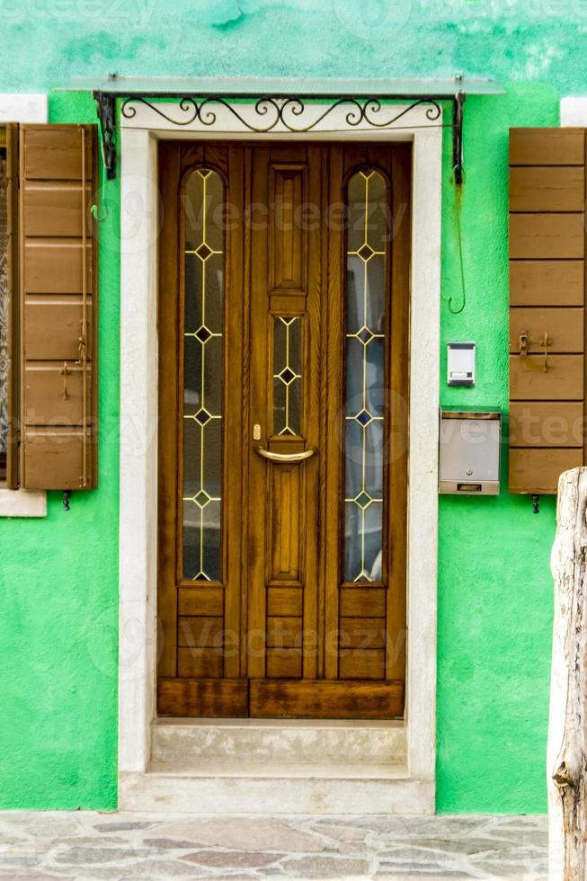 Old traditional door on colorful building at Burano island, Italy photo