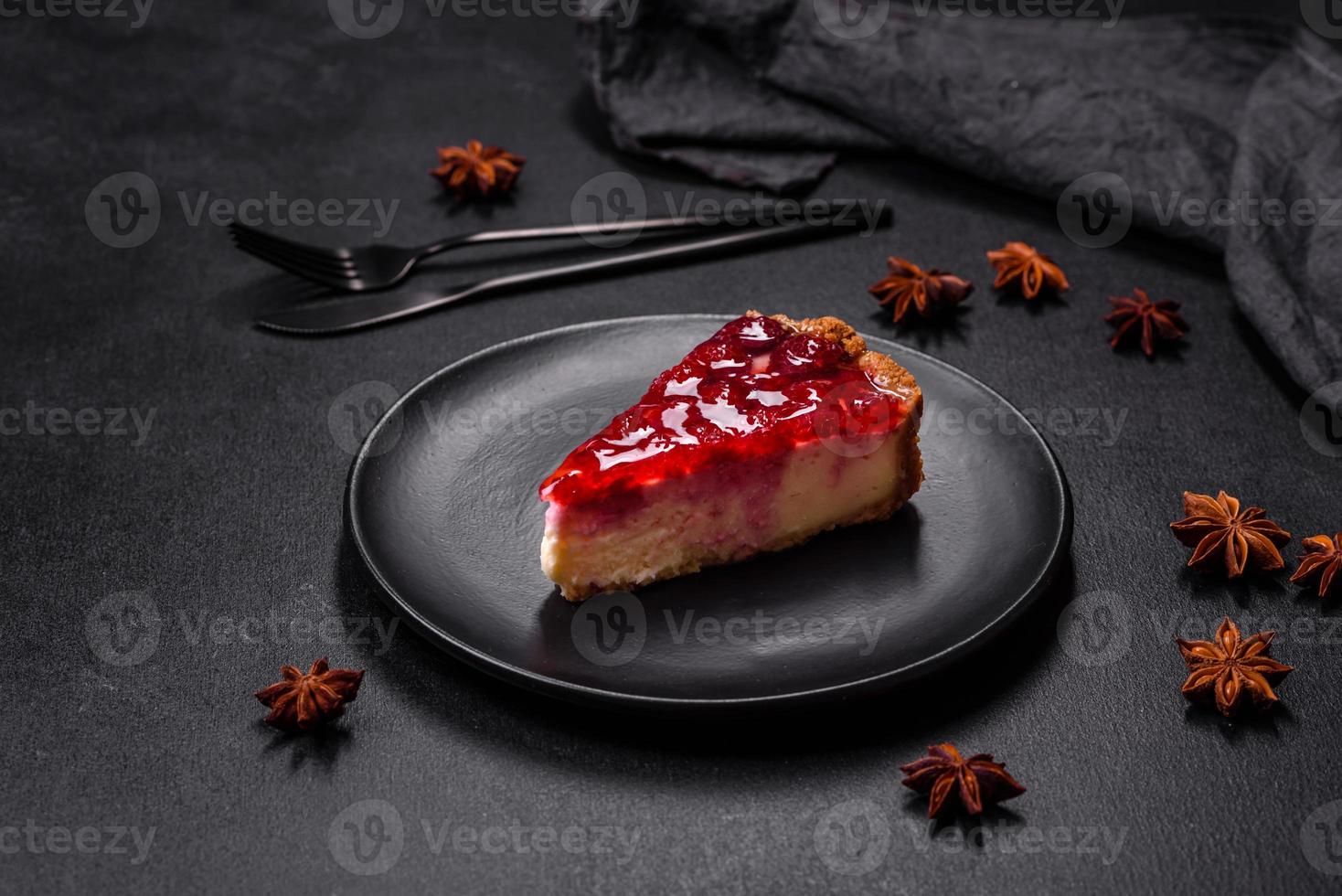 Homemade tasty cheesecake with jelly and raspberry berries on a black plate photo