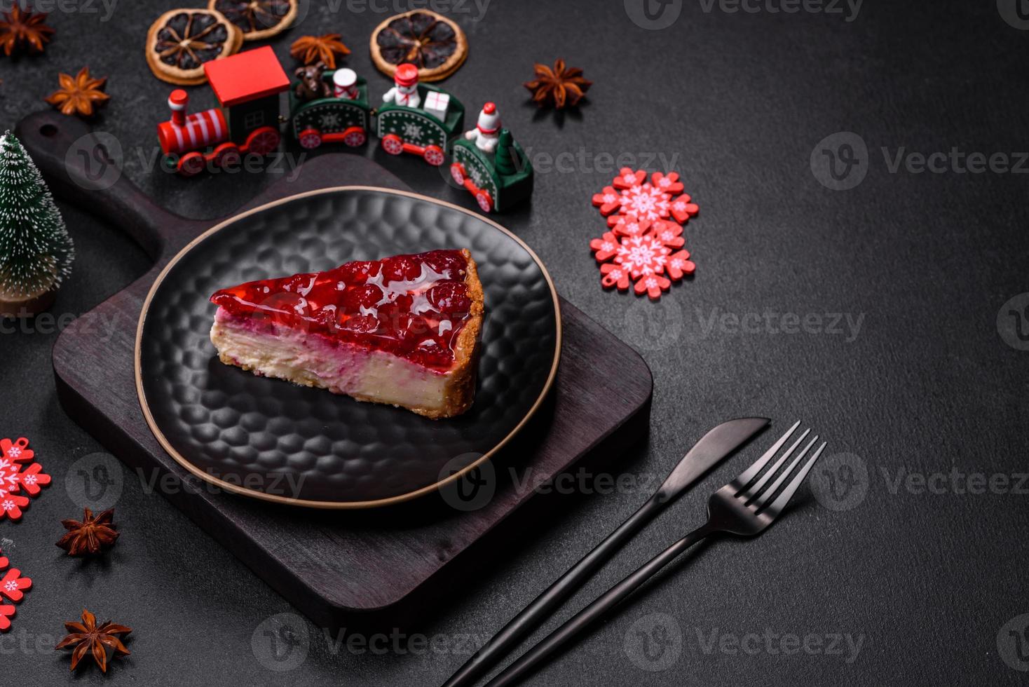 Homemade tasty cheesecake with jelly and raspberry berries on a black plate photo