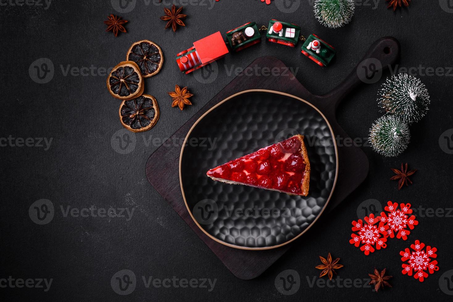 Homemade tasty cheesecake with jelly and raspberry berries on a black plate photo