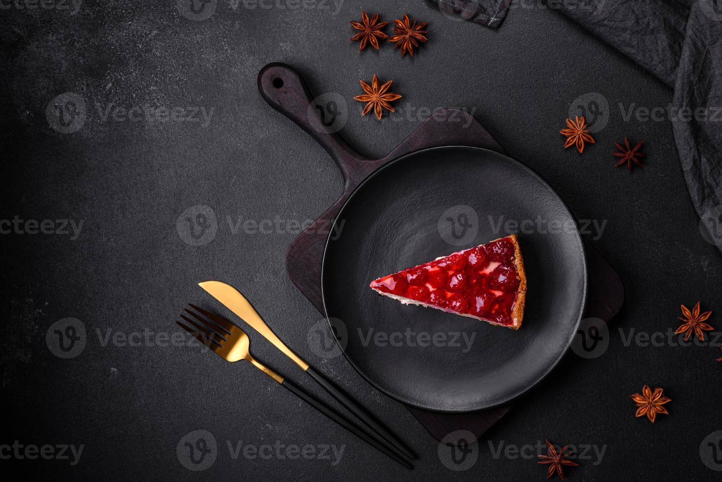 Homemade tasty cheesecake with jelly and raspberry berries on a black plate photo