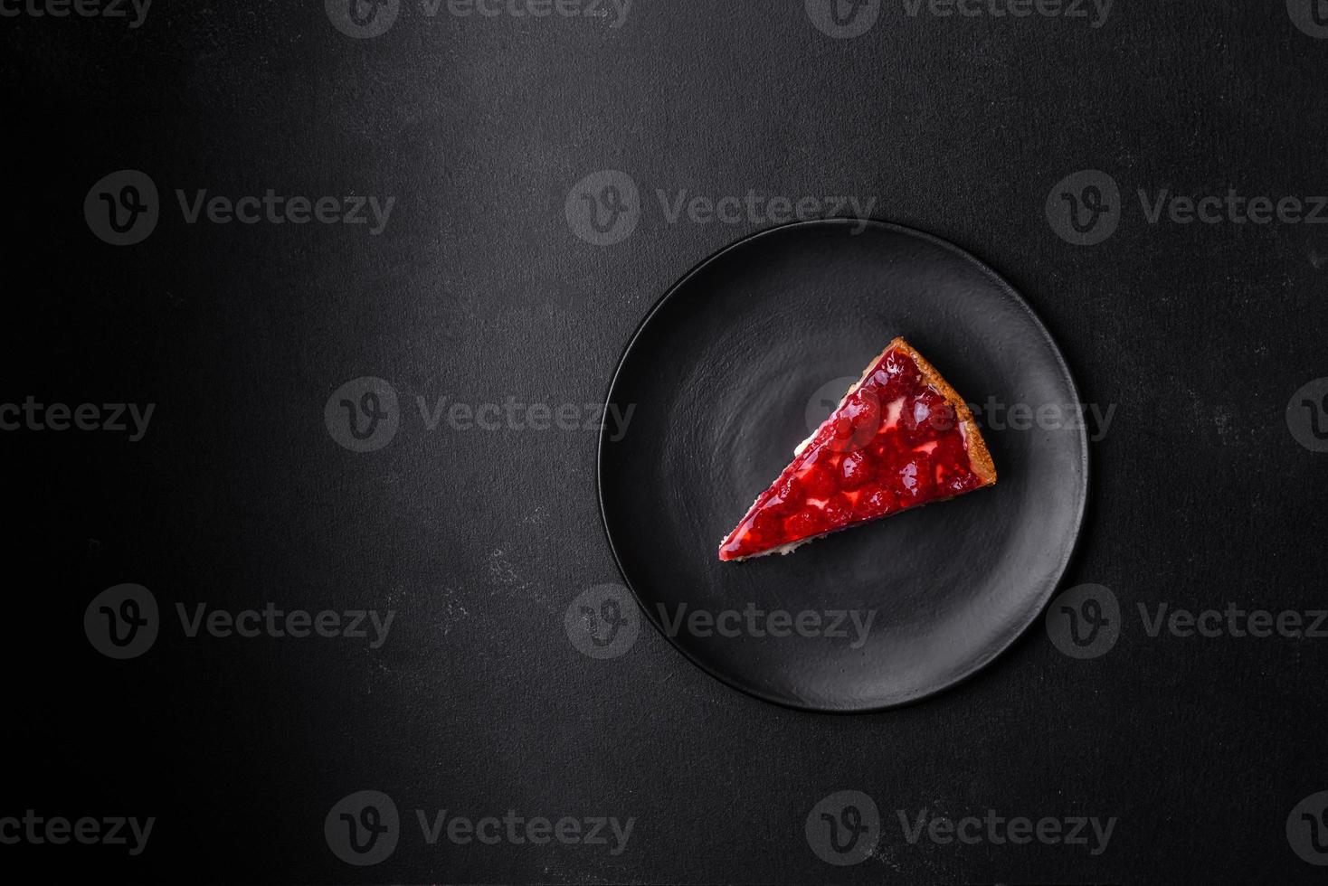 Homemade tasty cheesecake with jelly and raspberry berries on a black plate photo
