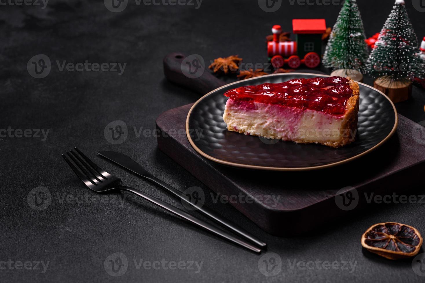 Homemade tasty cheesecake with jelly and raspberry berries on a black plate photo