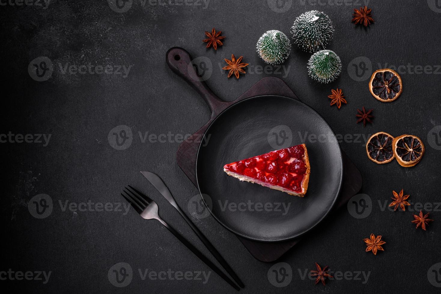 Homemade tasty cheesecake with jelly and raspberry berries on a black plate photo
