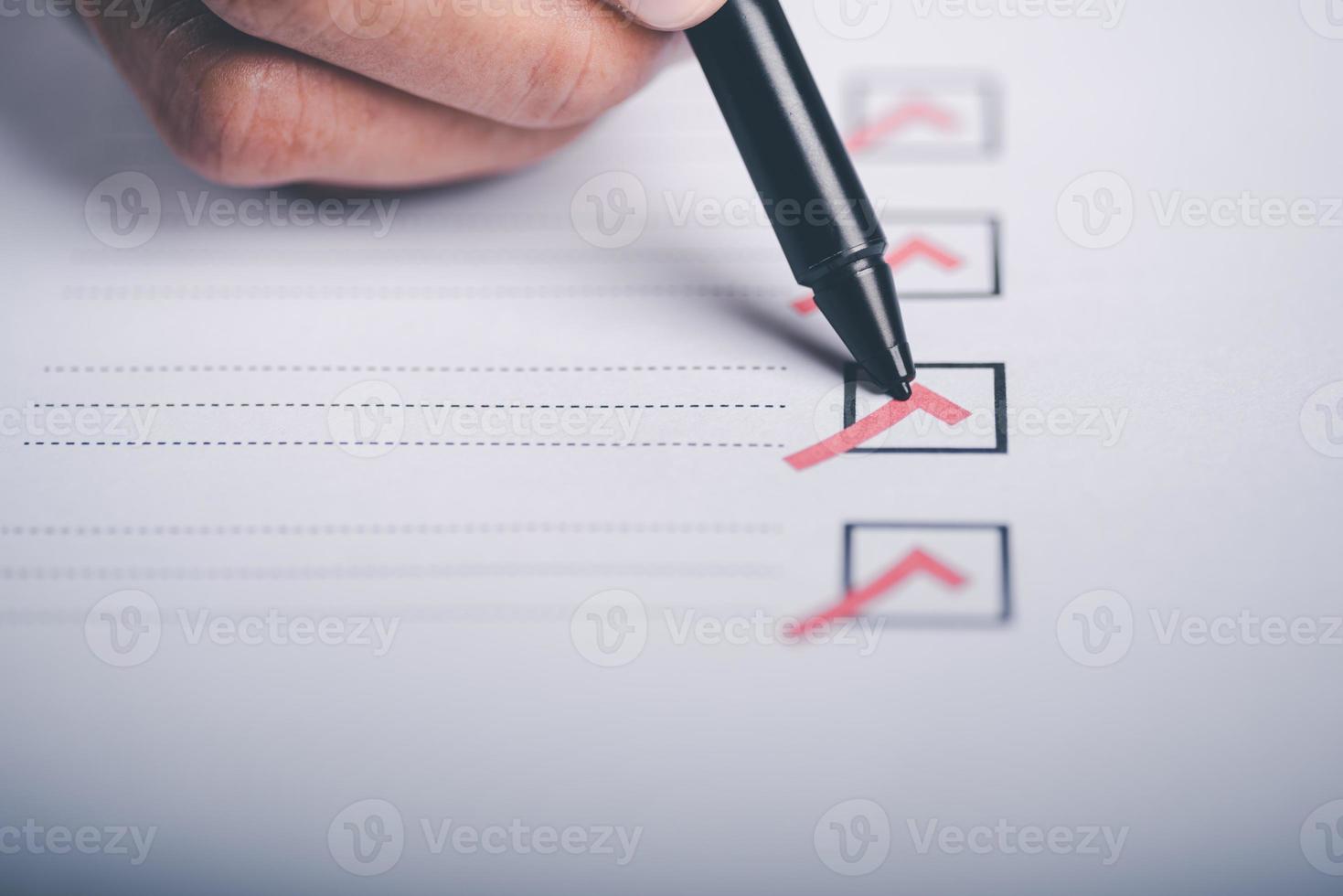 human hand check mark on paper,check concept through checkboxes, surveys through questionnaires, comments to lead Develop and fix bugs,Marking On Checklist photo