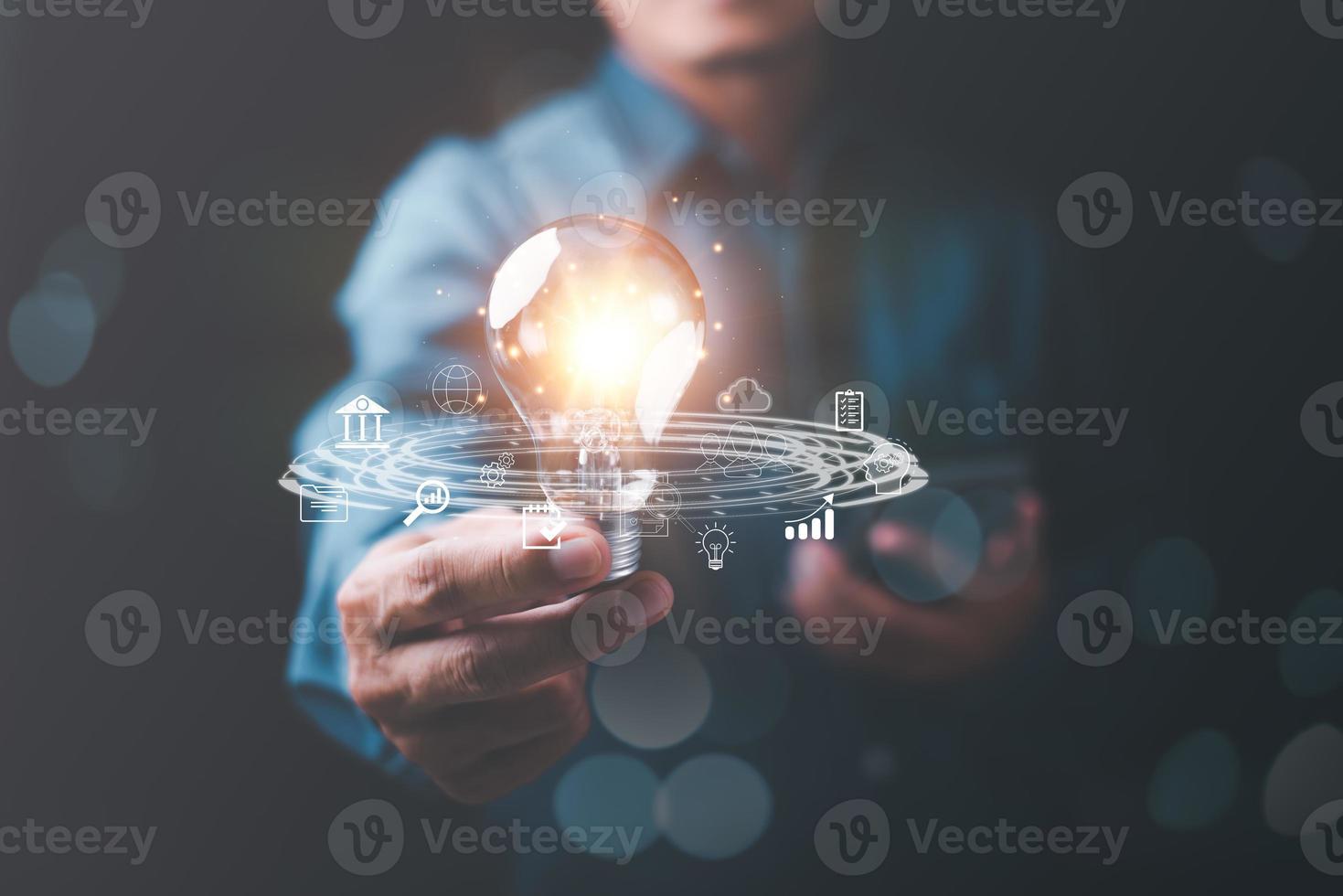 businessman holding light bulb in hand, virtual icons representing big data concepts, cyberspace technology and internet network databases, innovative connections and communications around the world. photo
