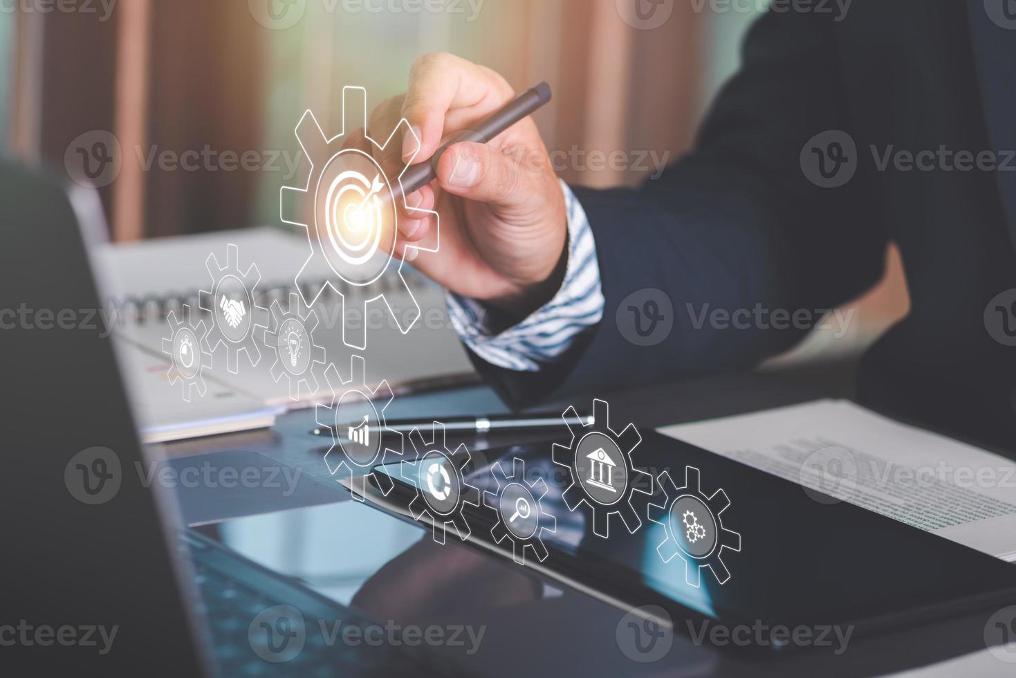 Businessman pointing pen at icon, goal setting ideas and business strategies. through planning and teamwork To analyze and develop company performance from growth data to the future. photo