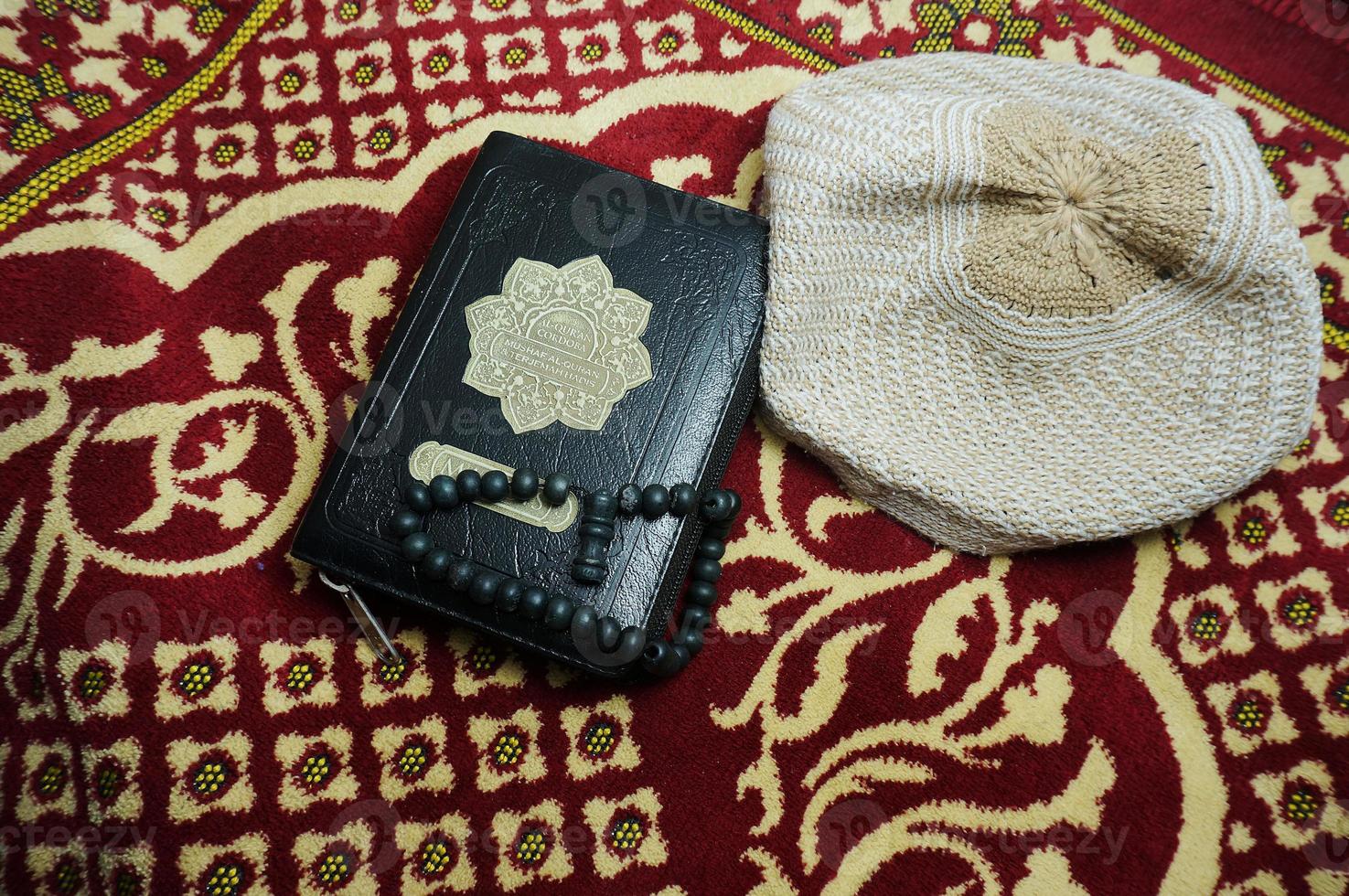 al quran con indonesia se traduce en una alfombra de oración. Corán es un libro sagrado islámico para musulmanes. foto