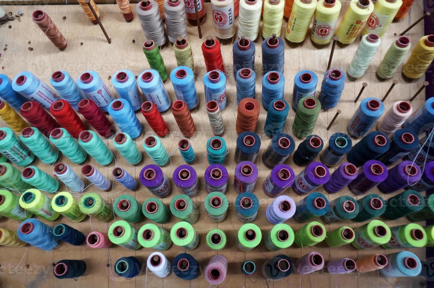 carretes de hilo de colores utilizados en la industria textil y de tejidos, con enfoque selectivo foto