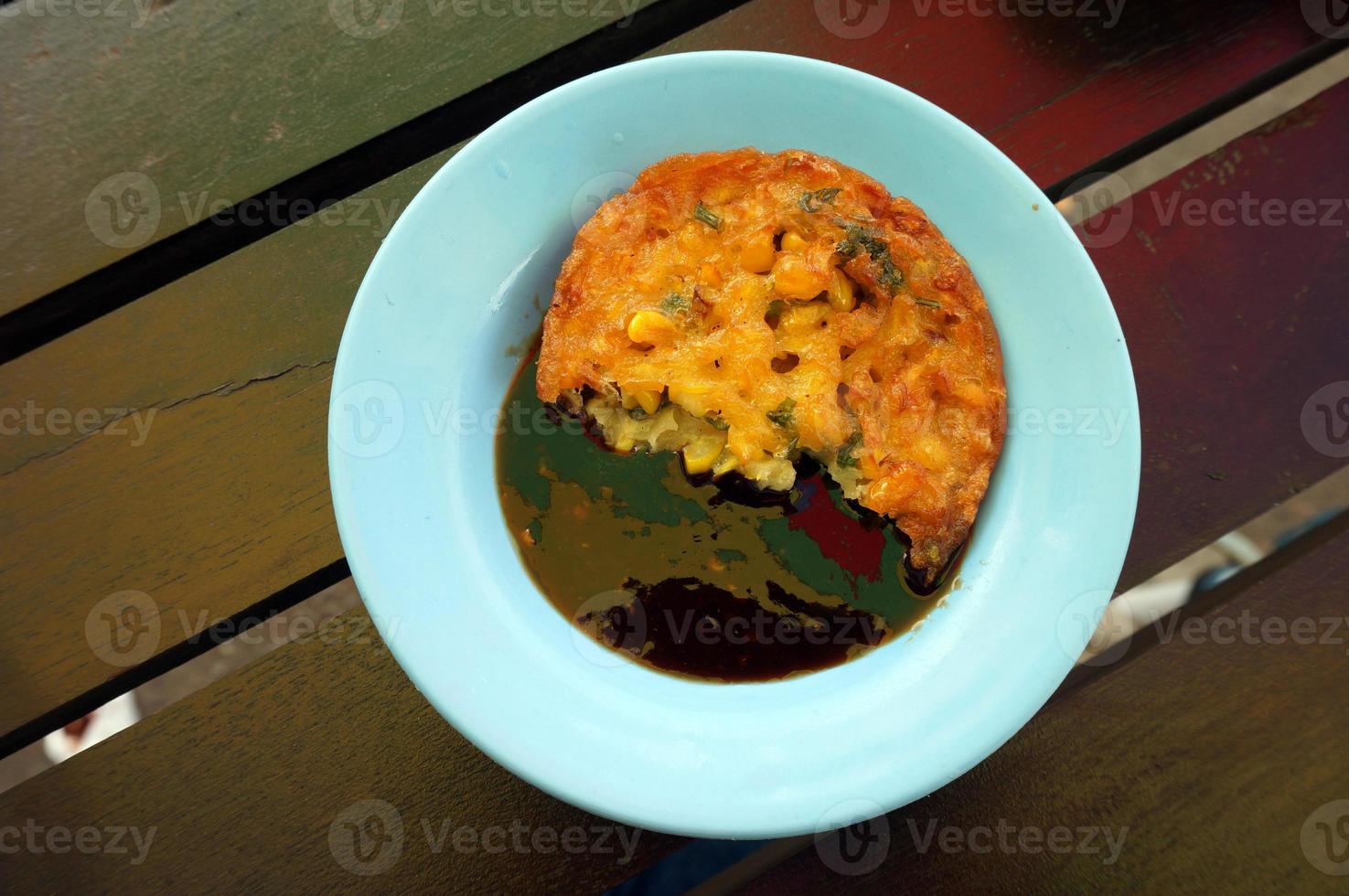 bakwan jagung o buñuelos de maíz. buñuelos de maíz ya comidos con salsa de soya petis foto