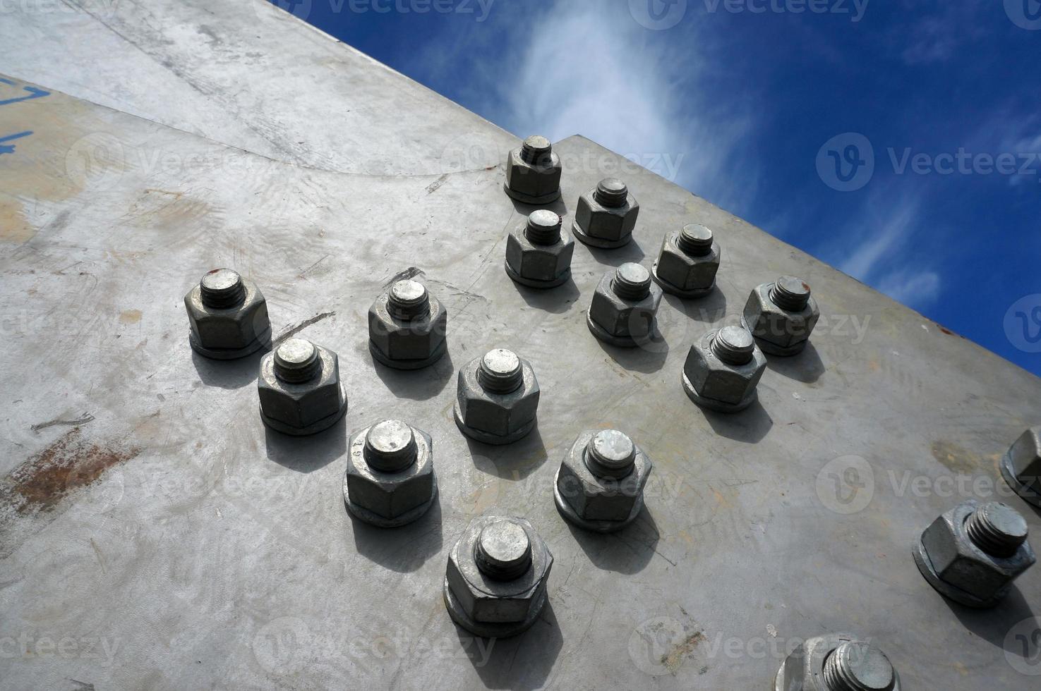 Bolts on a fragment of a massive girder bridge gray. photo