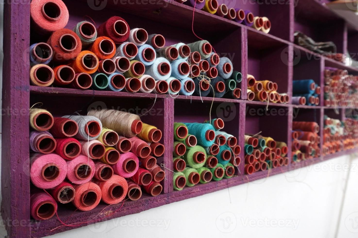 carretes de hilo de colores utilizados en la industria textil y de tejidos, con enfoque selectivo foto
