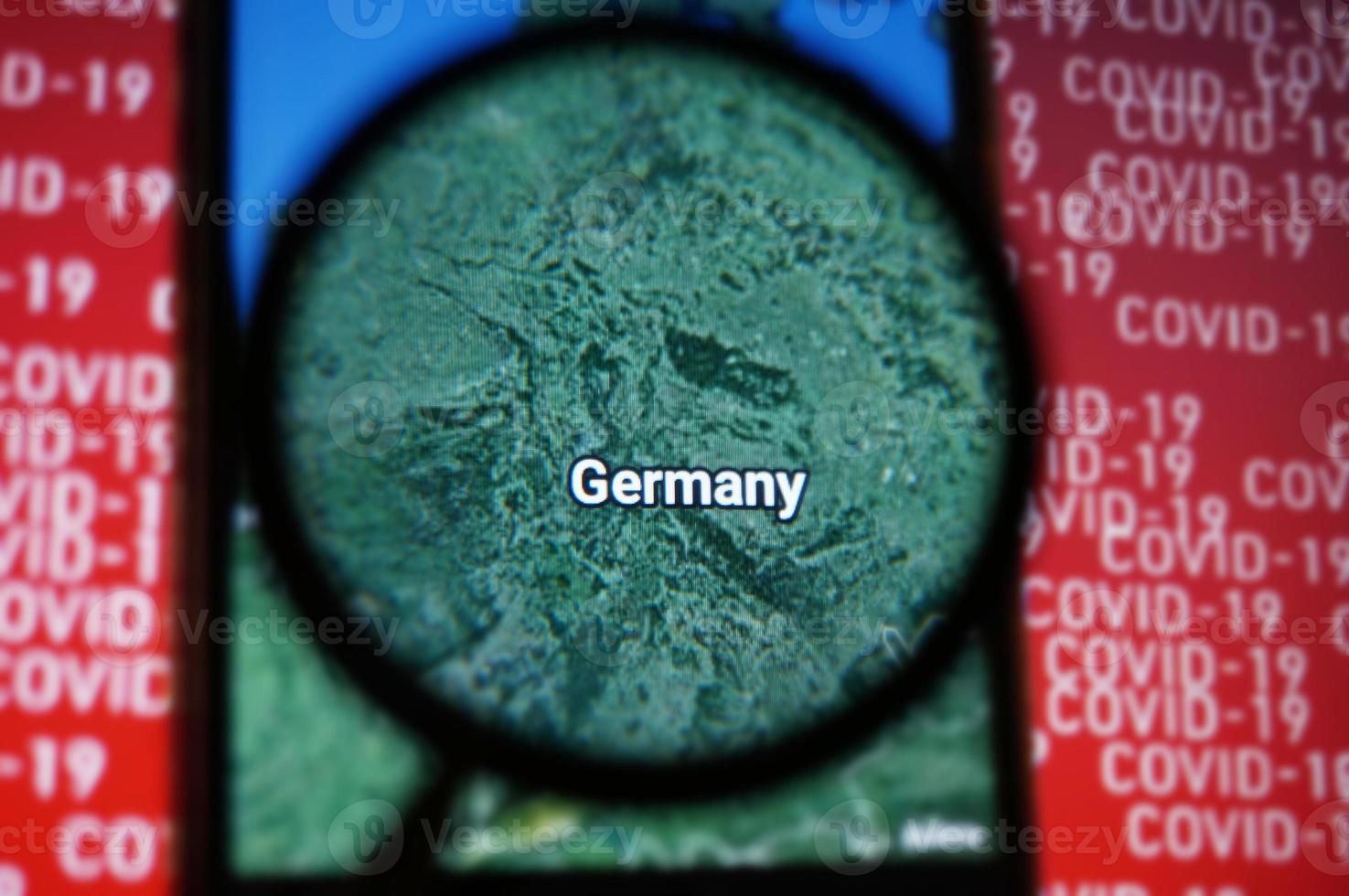 Germany country on google maps under magnifying glass with Red Covid-19 text Background. Selective Focus. photo