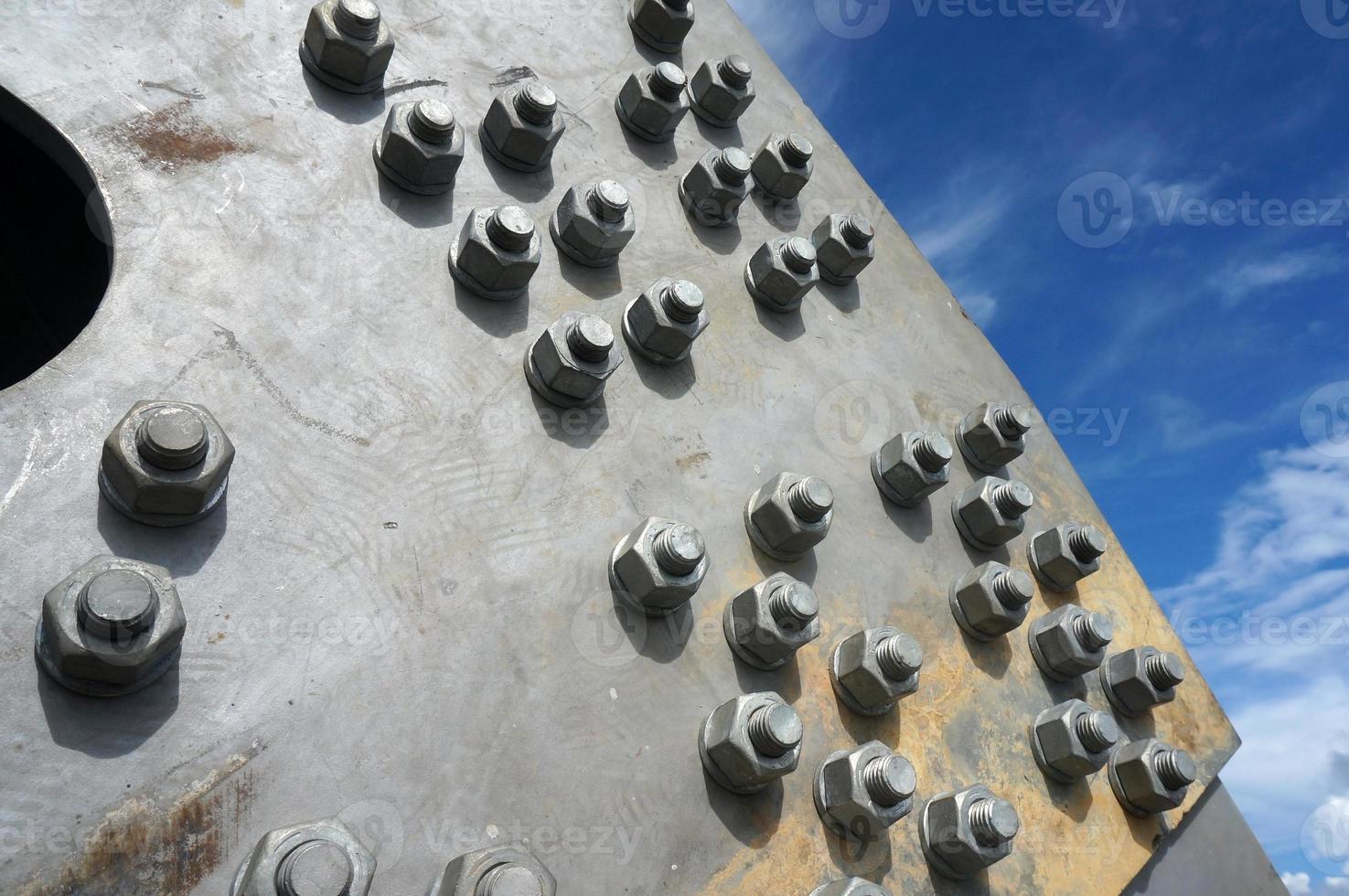 Bolts on a fragment of a massive girder bridge gray. photo