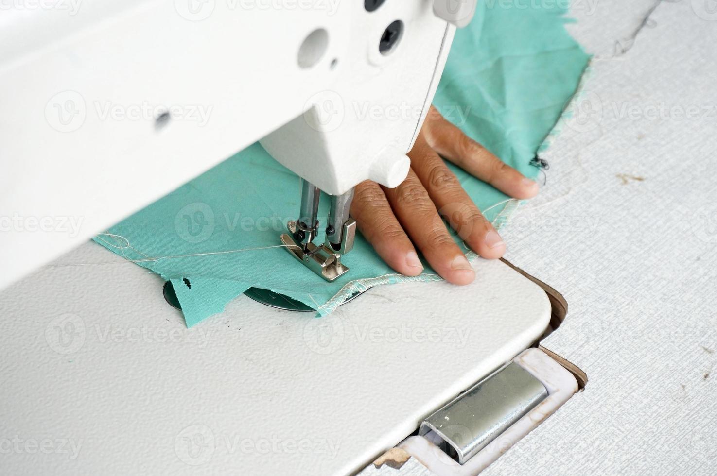 sewing a green dress on a sewing machine, With Selective Focus photo