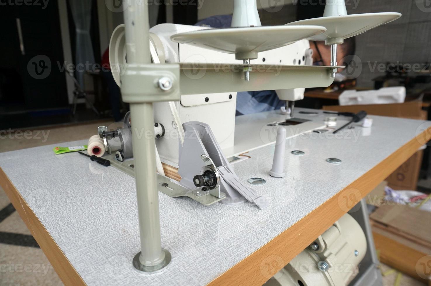 an old man fixing a sewing machine, With Selective Focus photo